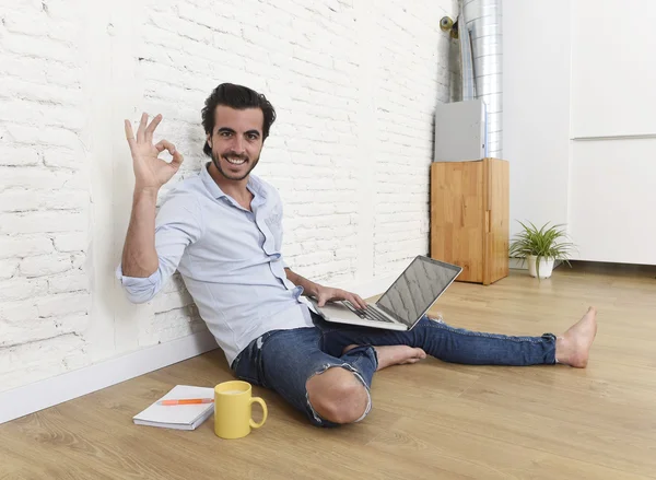 Young man in hipster modern casual style look sitting on living room home floor working on laptop — Zdjęcie stockowe