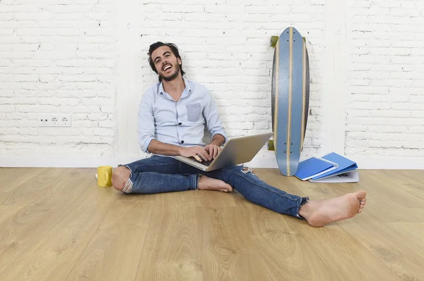 Young man in hipster modern casual style look sitting on living room home floor working on laptop — Stock Photo, Image