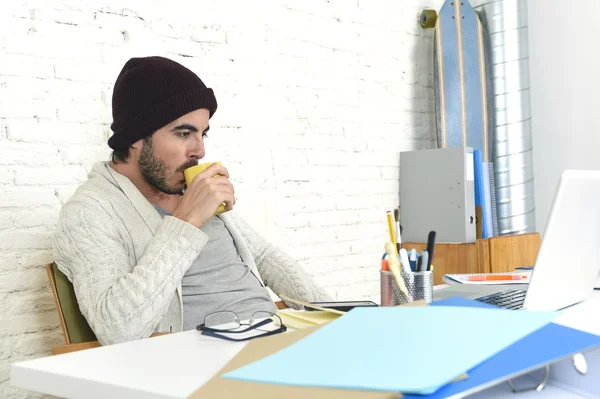Trendig affärsman i cool hipster mössa dricka kaffe arbetar lycklig i moderna hemmakontor — Stockfoto