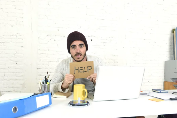 Worried businessman in cool hipster beanie look holding help sign working in stress at home office — Stockfoto