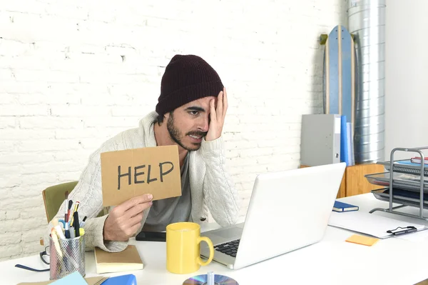 Homem de negócios preocupado em cool olhar gorro hipster segurando sinal de ajuda trabalhando em estresse no escritório em casa — Fotografia de Stock