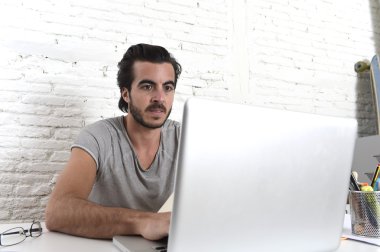 young modern hipster style student or businessman working with laptop computer at home office