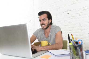 young modern hipster style student or businessman working with laptop at home office