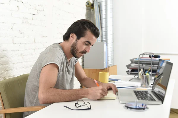 Молодой современный хипстерский стиль студент или бизнесмен, работающий с ноутбуком в домашнем офисе писать — стоковое фото