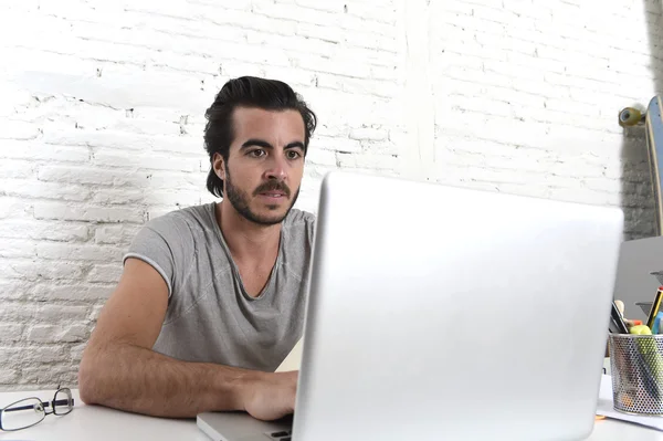 Jovem moderno hipster estilo estudante ou empresário trabalhando com computador portátil em casa escritório — Fotografia de Stock