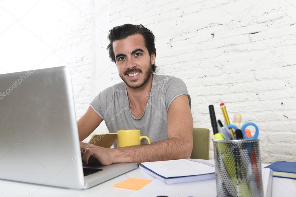 young modern hipster style student or businessman working with laptop at home office