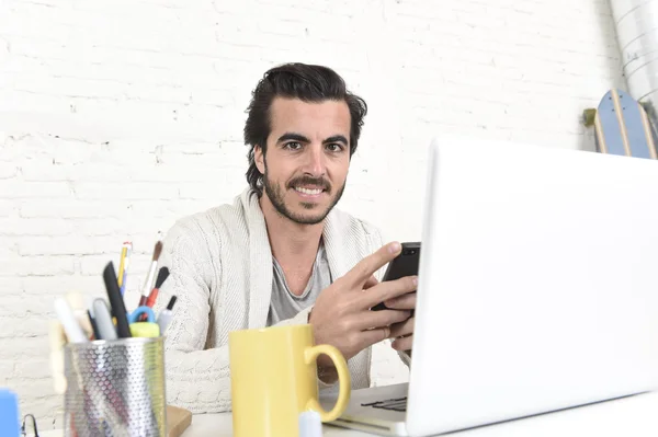 Attractive student or hipster style freelancer businessman working with laptop computer and mobile phone — Stock Photo, Image