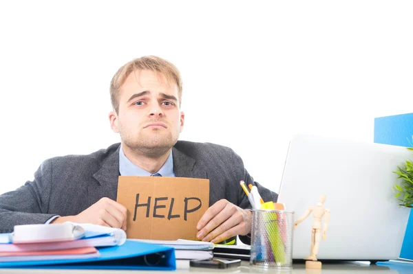 Junger verzweifelter Geschäftsmann, der ein Hilfeschild in der Hand hält, blickt besorgt auf Arbeitsstress am Computertisch — Stockfoto