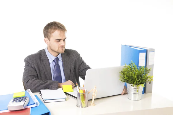 Junger attraktiver Geschäftsmann, der am Schreibtisch mit Laptop beschäftigt ist und zufrieden lächelt — Stockfoto