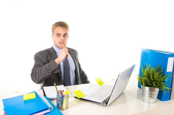 Привлекательный бизнесмен, работающий с ноутбуком пишущий на планшете с ручкой за столом офиса — стоковое фото