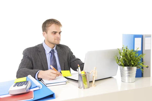 Junger attraktiver Geschäftsmann, der am Schreibtisch mit Laptop beschäftigt ist und zufrieden lächelt — Stockfoto