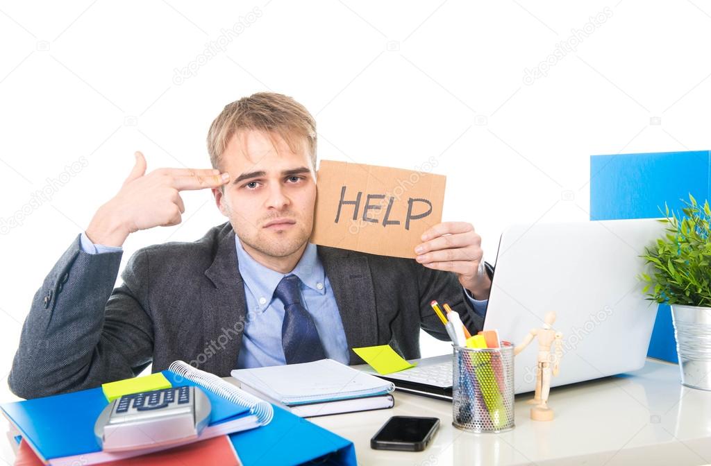 young desperate businessman holding help sign looking worried suffering work stress at computer desk