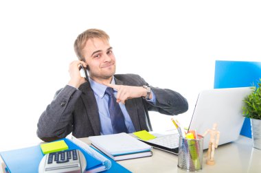 Kendine güvenen cep telefonu üzerinde ofis bilgisayar masası konuşurken gülümseyen genç mutlu işadamı