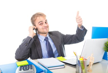 Kendine güvenen cep telefonu üzerinde ofis bilgisayar masası konuşurken gülümseyen genç mutlu işadamı