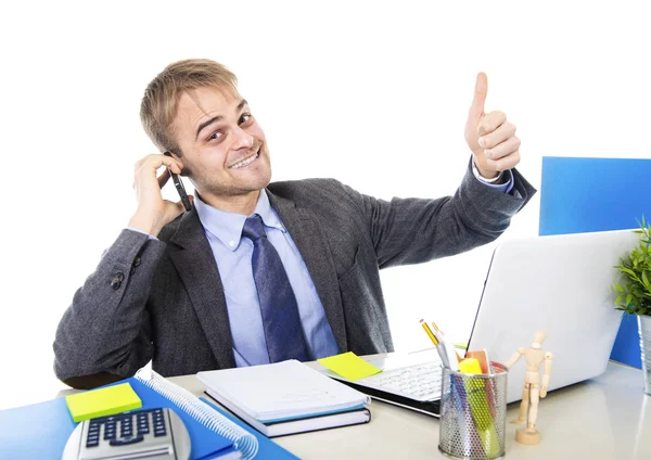 Joven feliz hombre de negocios sonriendo confiado hablando en el teléfono móvil en escritorio de la computadora de la oficina — Foto de Stock