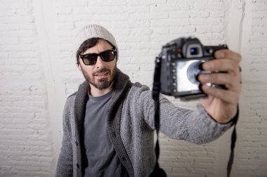 selfie çekim video fotoğraf makinesi ve fotoğraf tutan genç blogger adam hippi tarzı