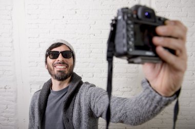 selfie çekim video fotoğraf makinesi ve fotoğraf tutan genç blogger adam hippi tarzı