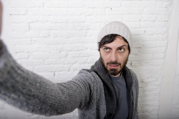 Joven hipster blogger hombre sosteniendo fuera de pantalla teléfono móvil disparo selfie imagen o vídeo —  Fotos de Stock