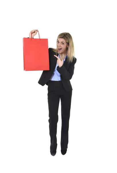 Giovane donna bella felice in abito da lavoro in espressione viso eccitato tenendo borsa della spesa rossa — Foto Stock