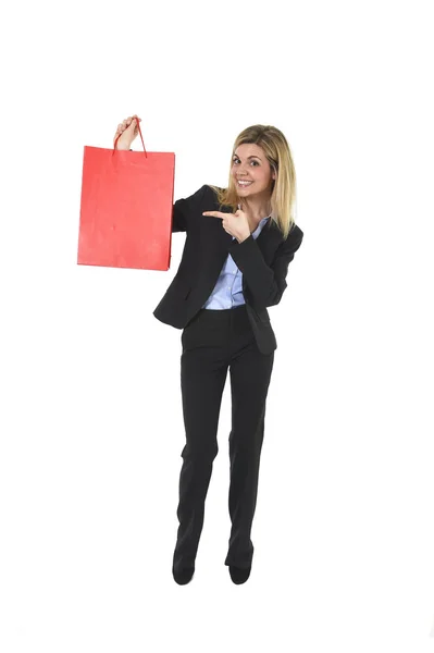 Young happy beautiful woman in business suit in excited face expression holding red shopping bag — Stock Photo, Image