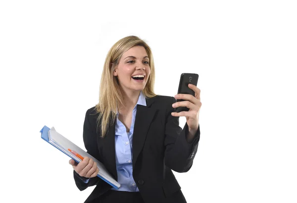 Kobieta interesu młody piękny blond włosy za pomocą Internetu aplikacja na telefon komórkowy gospodarstwa folderze office i pióra uśmiechający się zadowolony — Zdjęcie stockowe