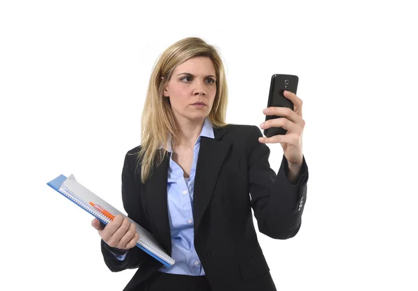 Businesswoman using internet app on mobile phone holding office folder and pen looking busy — Stock Photo, Image