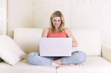 ev kanepe dizüstü bilgisayar mutlu gülümseyen içinde internet kullanımı rahat yatan genç kadın 