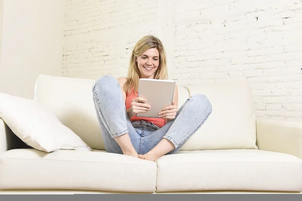 Junge glückliche Frau auf dem heimischen Sofa mit Internet-App auf digitalem Tablet-PC — Stockfoto