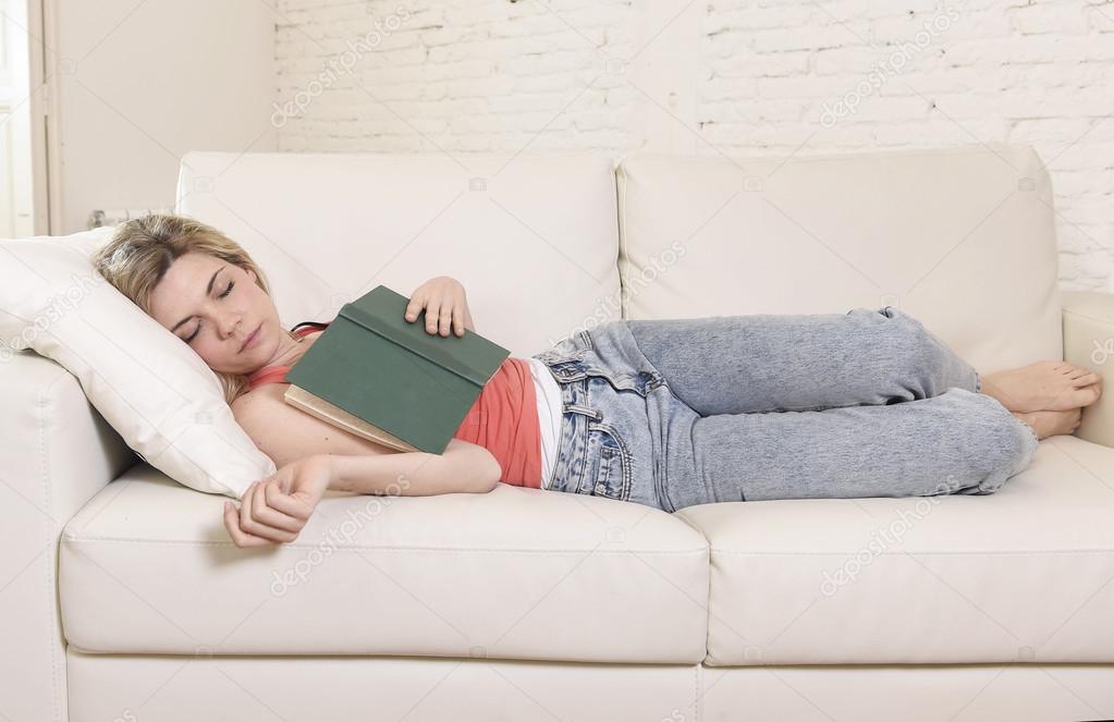young beautiful caucasian woman sleeping while reading book or studying lying comfortable