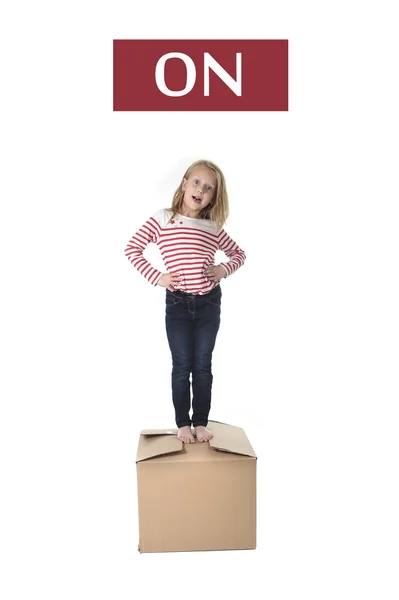 Doce loiro cabelo criança olhando em cima da caixa de papelão isolado no fundo branco na aprendizagem de inglês — Fotografia de Stock