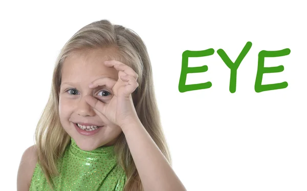 Linda niña dando vueltas ojo en partes del cuerpo aprendiendo palabras en inglés en la escuela — Foto de Stock