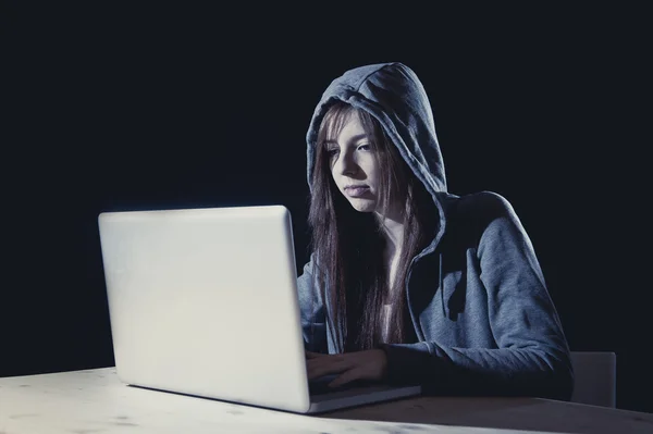 Young attractive teen woman wearing hood on hacking laptop computer cybercrime cyber crime concept — Stock Photo, Image