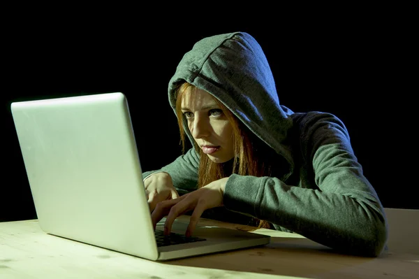 Young attractive teen woman wearing hood on hacking laptop computer cybercrime cyber crime concept — Stock Photo, Image