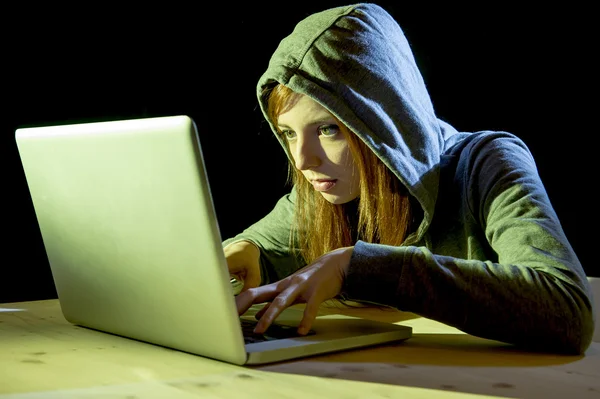 Young attractive teen woman wearing hood on hacking laptop computer cybercrime cyber crime concept — Stock Photo, Image