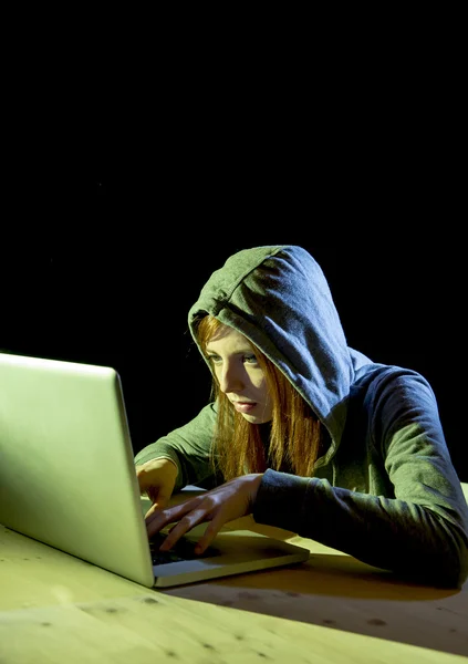 Young attractive teen woman wearing hood on hacking laptop computer cybercrime cyber crime concept — Stock Photo, Image