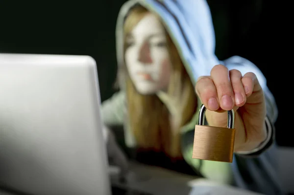 年轻迷人的少女头戴风衣，黑客攻击手提电脑 — 图库照片