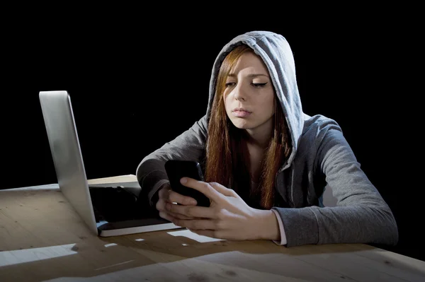 Adolescente hacker ragazza nel cappuccio utilizzando il telefono cellulare in Internet cyber crime esperto o cybercrime — Foto Stock