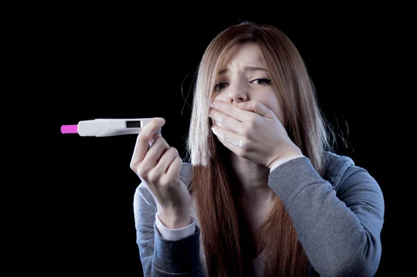 年轻女人害怕和震惊持有妊娠试验阳性结果看起来不开心 — 图库照片