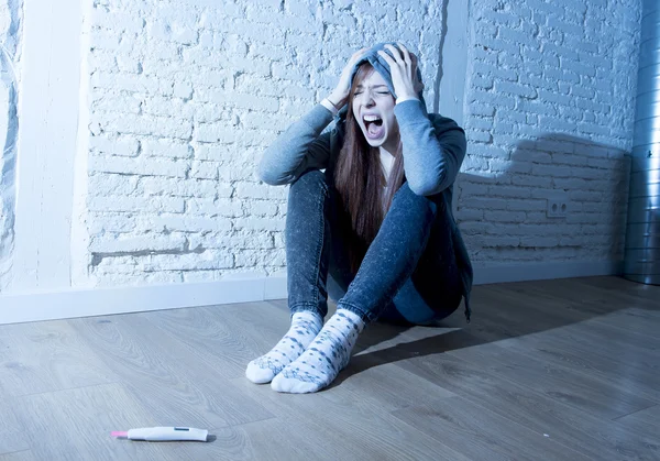 Young teenager girl or young woman in shock scared after positive pregnancy test — Stock Photo, Image