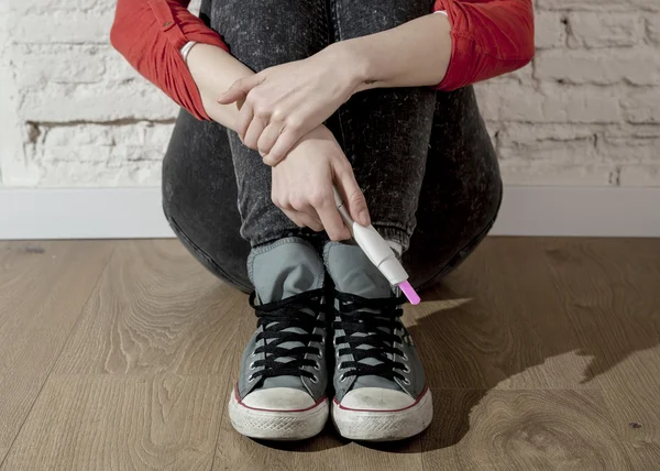 Zwangere tiener meisje of jonge wanhopige vrouw met positieve roze zwangerschapstest — Stockfoto