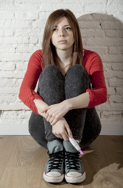 Assustado preocupado adolescente grávida ou jovem mulher desesperada segurando teste de gravidez positivo — Fotografia de Stock