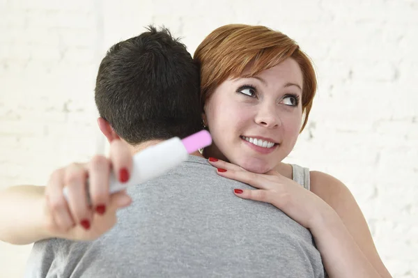 Jovem mulher feliz abraçando marido segurando resultado positivo teste de gravidez esperando um bebê — Fotografia de Stock