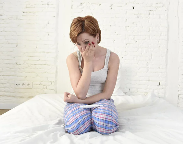 Молодая грустная женщина плачет расстроенная после проверки отрицательного или положительного теста на беременность — стоковое фото