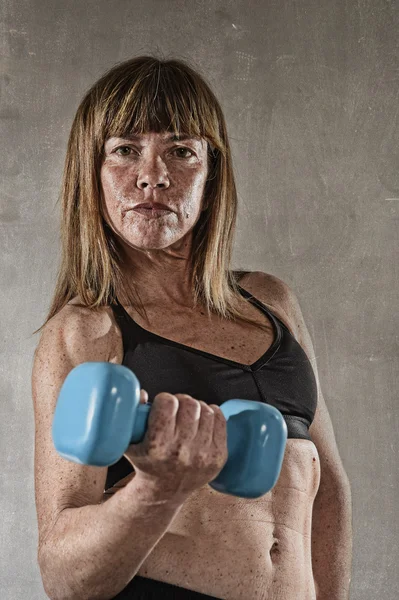 En forma y fuerte mujer del deporte sosteniendo el peso en su mano posando desafiante en actitud fresca —  Fotos de Stock