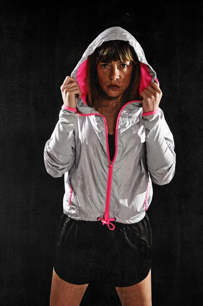 Strong sport freckles woman wearing training jacket hood on posing defiant — Stock Photo, Image