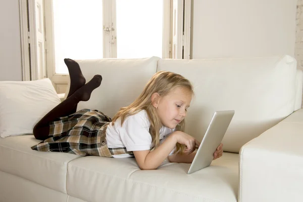 Doce menina deitada em casa sofá sofá usando o aplicativo de internet no tablet pad digital — Fotografia de Stock