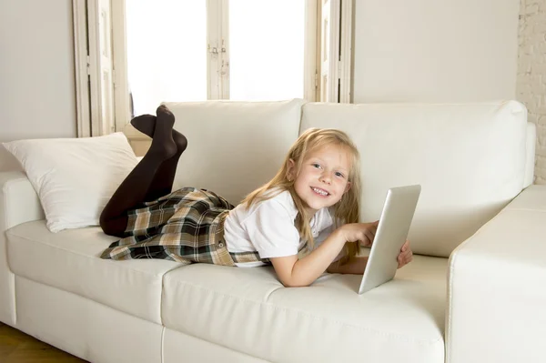 Doce menina deitada em casa sofá sofá usando o aplicativo de internet no tablet pad digital — Fotografia de Stock