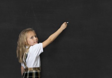 mutlu ve gülümseyerek tebeşir yazı tahtası ile yazma duran sarı saçlı genç tatlı genç kız öğrenci