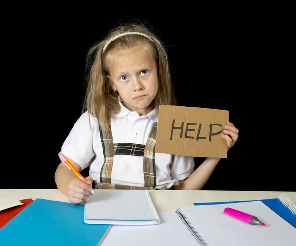 Fatigué mignon junior écolière avec des cheveux blonds assis dans le stress de travail faire des devoirs à la recherche ennuyé — Photo