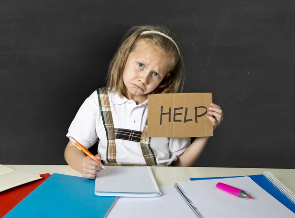 Fatigué mignon junior écolière avec des cheveux blonds assis dans le stress de travail faire des devoirs à la recherche ennuyé — Photo